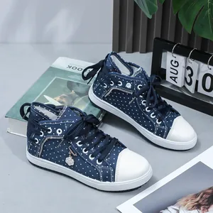 Close-up detail of navy blue polka dot high-top sneakers with side zipper and flower charm