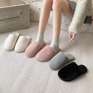 Detail showing soft plush texture of indoor slippers in white, pink, grey, and black