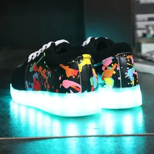 Detail view of black graffiti sneakers featuring glowing LED soles with USB charging