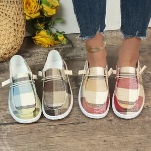 Detail view of colorful checkered canvas loafers for women with elastic laces and white soles