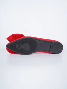 Close-up detail showing the non-slip black rubber sole of a red bow-knot flat shoe