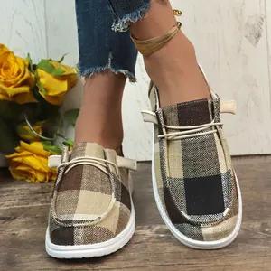 Stylish brown plaid canvas loafers on model, flat casual slip-on boat shoes for women.