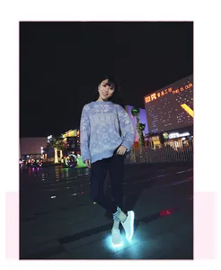 Stylish white USB charging LED light up sneakers worn by a model in a night street