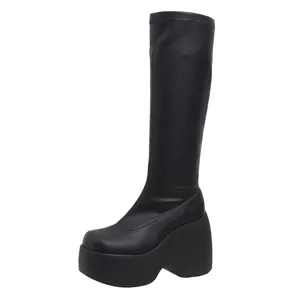 Side view of black platform wedge tall boots with square toe and elastic leather finish