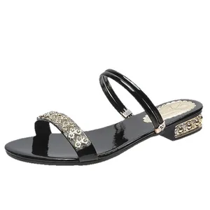 Elegantes sandalias de charol negro con tacón medio y tiras de pedrería.