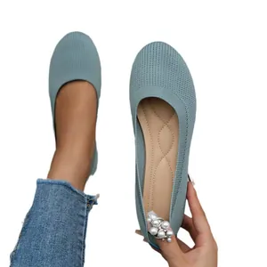 Close-up detail of stylish teal knitted ballet flats featuring elegant pearl heel ornament