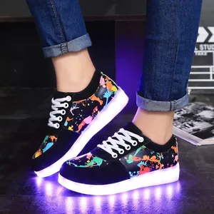 Close-up of LED light-up sneakers with colorful graffiti pattern and glowing soles