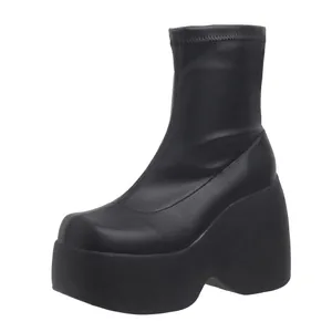 Detailed side view showing the black platform sole and square toe of these stretch boots