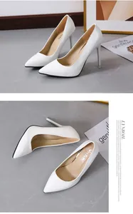 Detailed view of elegant white patent leather stiletto pumps featuring a sharp pointed toe