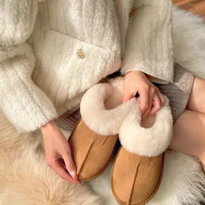 Detail of warm camel slippers with thick white faux fur lining and soft suede finish
