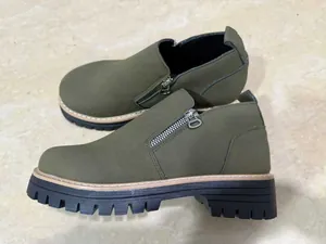 Detailed side view of olive green women's short boots with side zipper and lug sole.