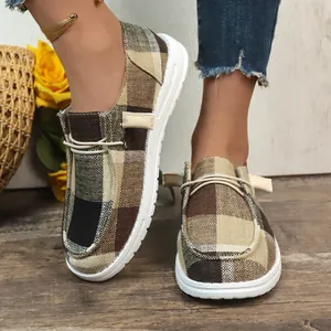 Detail view of women's plaid canvas slip-on shoes with comfortable white soles