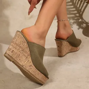 Close-up of olive green suede wedge sandals with stylish cork-textured platform sole