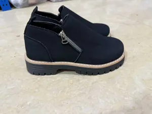 Close-up of black round toe Martin boots with side zipper and thick sole