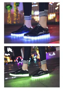 Detail view of black LED light-up sneakers showing vibrant blue and green glowing soles