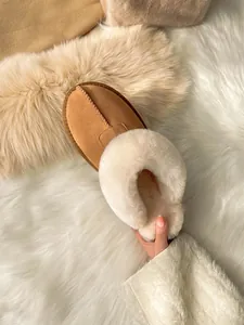 Detailed macro shot of camel suede slipper featuring thick plush white faux fur lining
