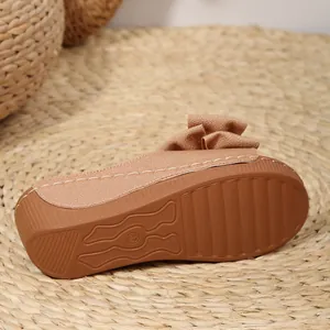 Detailansicht einer braunen Keilsandalette mit rutschfester Sohle und Stoffschleife