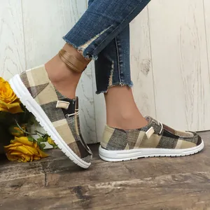 Detailed macro shot of comfortable brown plaid canvas slip-on loafers for casual women wear