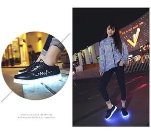 Close-up of black LED light-up sneakers with USB charging and glowing sole.