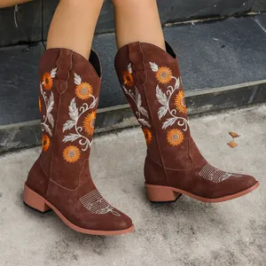 Detail of brown western cowboy boots featuring sunflower embroidery and block heel