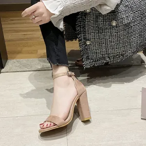 Close-up of beige suede block heel sandals with elegant ankle strap and open toe design.