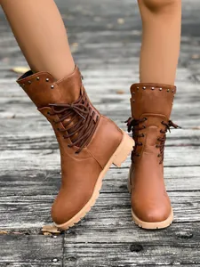 Detailansicht der stilvollen braunen Damen-Winterstiefel mit Schnürung und Silbernieten