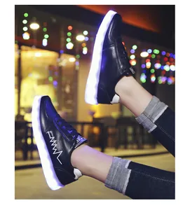 Close-up of black LED light-up sneakers with glowing soles in a night setting