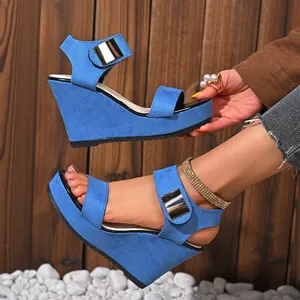 Detailansicht blauer Keilsandaletten mit goldener Schnalle und modischem Peep-Toe-Design