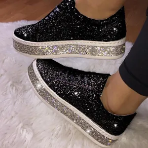 Vista de las zapatillas negras de plataforma con purpurina y suelas con pedrería plateada.