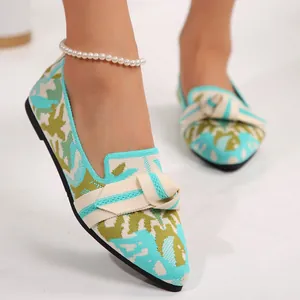 Vista detallada de mocasines de punto elegantes con un lazo decorativo y estampado vivo.