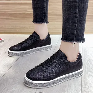 Primer plano detallado de zapatillas de plataforma con purpurina negra y suela plateada.