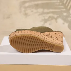 Detalle de sandalia con cuña verde oliva con suela de corcho y fondo estriado.