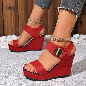 Rote Wildleder-Keilsandalen mit funkelndem Strass-Knöchelriemen und Goldschnallen-Detail.