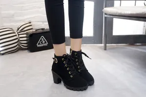 Close-up detail of stylish black suede lace-up ankle boots with chunky high heels