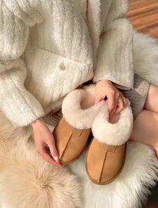 Detailed view of camel suede winter loafers with thick white plush faux fur lining