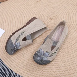 Close-up of the elegant floral embroidery on beige slip-on casual shoes for women