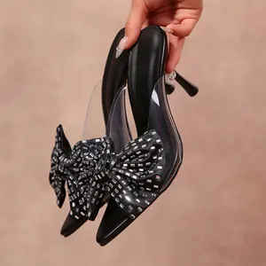 Vue détaillée de mules à talons hauts pour femmes avec nœud en strass et bout pointu en noir