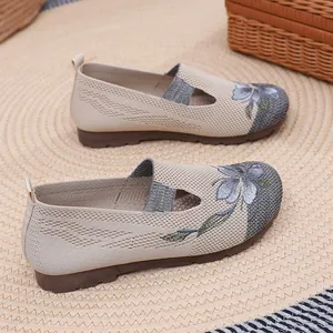 Detail of beige knitted slip-on shoes with elegant floral embroidery and soft sole