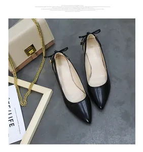 Elegant black pointed-toe high heels with heel bow detail on grey background