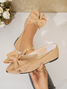 Close-up of champagne glitter ballet flats with large bow and square toe detail