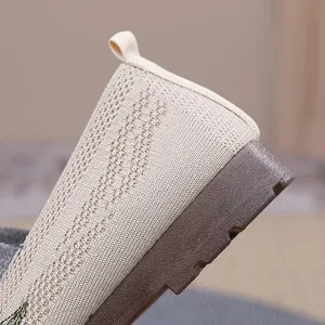 Close-up detail of the breathable beige knit fabric and soft brown sole on women's slip-on