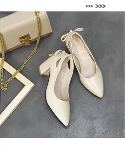 Close-up of beige pointed-toe pumps featuring an elegant bow detail on the heel
