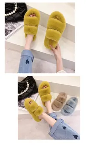Close-up of fuzzy two-strap indoor slippers in yellow, beige and blue fuzzy faux fur