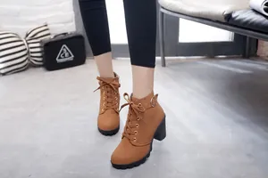 Detail view of brown chunky heel platform lace-up ankle boots on a model
