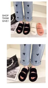 Close-up of black faux fur double strap slippers worn with heart pattern jeans