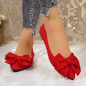 Close-up detail of red pointed-toe ballet flats with elegant large bow decoration