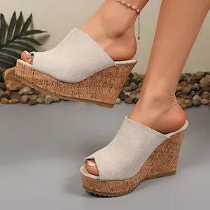 Detail shot of women's peep-toe wedge slides with suede upper and cork platform.