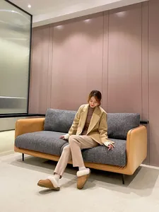 Women's warm fur-lined snow slippers styled with a tan blazer and knit pants