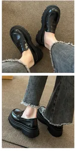 Detailed close-up view of vintage black chunky platform loafers featuring a glossy finish