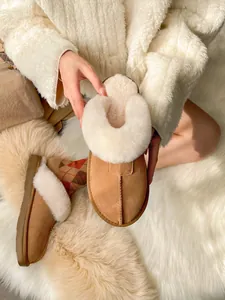 Close-up detail of warm chestnut suede snow slippers with soft white faux fur lining